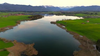Oberbayern bei Sonnenuntergang 'dan Der Riegsee. Murnau, Bavyera, Almanya, Avrupa yakınlarındaki Riegsee Gölü 'nün havadan görüntüsü. Baharda gün batımında arka planda Ammergauer Alpen. Turizm Bölgesi Das Blaue Arazisi. 