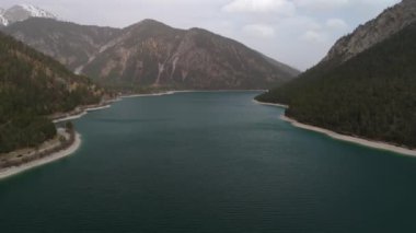 Avusturya Alplerinde gökyüzü manzaralı bir göl. Tirols Plansee 'yi görün. Plansee im Bezirk Reutte, Tirol, Osterreich innerhalb der Ammergauer Alpen. Avusturya 'da büyük temiz bir göl. Dağlarda rezervuar. 