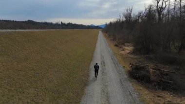 Bisikletçiler, Almanya 'nın Bavyera eyaletinde Rosenheim nehri boyunca bisiklet yolu üzerinde bisiklet sürerler. Ben Innradweg bei Rosenheim. Deutschland 'da geniş bir nehir boyunca çakıllı bisiklet yolu. Üst Bayern 'de döngü. 