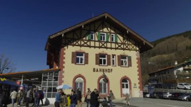 1 Mart 2024. Tegernsee, Almanya. Bahnhof Tegernsee im oberbayerischen Landkreis Miesbach. Güneşli havada Bavyera Alpleri 'ndeki tren istasyonu. Turşular, tren istasyonunda bir sürü insan trenden indi.. 