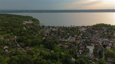 Ben Ammersee Luftaufnahme bei Sonnenuntergang 'ım. Almanya 'nın Bavyera şehrinde yaz günbatımında büyük Ammersee Gölü yakınlarında küçük bir Alman kasabası Herrsching' in havadan görünüşü. Ammer Gölü. 