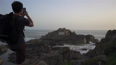 Farol da Boa Nova Portekiz, Porto 'da. Miradouro da Boa Nova. Okyanusta Capela da Boa Nova yakınlarında Oporto, Portekiz 'de gün batımında plakalı bir kaya. Hatıra mermer plaketi Antonio Nobre. 