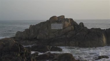 Farol da Boa Nova Portekiz, Porto 'da. Miradouro da Boa Nova. Okyanusta Capela da Boa Nova yakınlarında Oporto, Portekiz 'de gün batımında plakalı bir kaya. Hatıra mermer plaketi Antonio Nobre. 