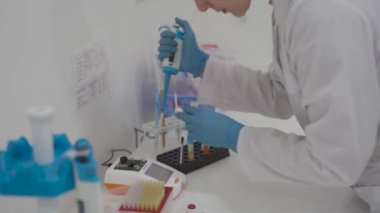 Kan analizi sırasında pipetli bir tıbbi laboratuvar asistanı. Hastane laboratuarlarındaki ekipmanlar. Hematolojik inceleme için damlatıcıyla araştırma görevlisi. Modern laboratuvarda bilim adamı.. 