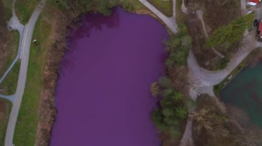 Allgau 'daki doğal manzara Gipsbruchweiher göleti Fussen, Bavyera, Almanya' da mor renkte parlar. Alçıtaşı taş ocağından çıkan yoğun mor renkli parlayan göl. Mor bakterilerin sebep olduğu fenomen. 