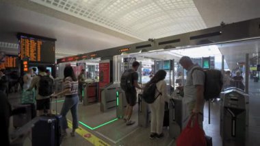 30 Ağustos 2023. Roma, İtalya. Roma Terminali 'nin otomatik bilet gişelerinden insanlar geçiyor. İstasyondaki demiryolu trenlerine giden turnikeler. İtalya 'daki demiryolu terminalinde bilet engeli