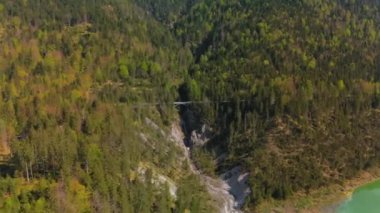 Luftaufnahme Schurpfen Wasserfall. Eğri şelale Schurpfen 'in hava manzarası ve Lenggries' deki Sylvensteinspeicher yakınlarında orman dağı ve kanyonla dolu bir köprü. İnsansız hava aracı görüntüsü düşüyor ve köprü. 