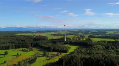 Almanya 'nın Ebersberg bölgesindeki Bavyera' daki rüzgar türbininin hava görüntüsü. Bayern, Deutschland 'deki Luftaufnahme einer Windtürbin vor dem Hintergrund der Alpen. Alplere bakan golf sahasında rüzgar türbini. 