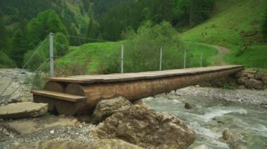 Kleine Holzbrucke kürkü Fussganger Uber den Fluss Trettach vadisi Oberstdorf, Allgaeu Alps, Allgaeu, Bavyera, Almanya. Sonbaharda Trettach dağlık nehir üzerindeki küçük ahşap köprü. 