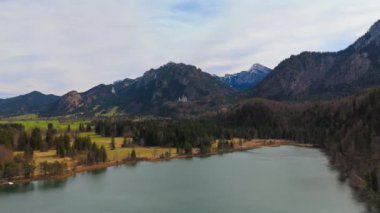 Schwansee Alp Gölü 'nden Neuschwanstein Şatosu baharda görülüyor. Schwansee im Ostallgau, Bayern sudostlich von Fussen im Gemeindegebiet von Schwangau 'da. Schloss Neuschwanstein und der See. 