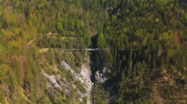 Luftaufnahme Schurpfen Wasserfall. Eğri şelale Schurpfen 'in hava manzarası ve Lenggries' deki Sylvensteinspeicher yakınlarında orman dağı ve kanyonla dolu bir köprü. İnsansız hava aracı görüntüsü düşüyor ve köprü. 