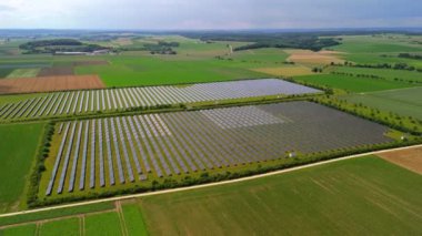 Almanya 'nın kırsal kesimlerinden birinde güneş enerjisiyle çalışan bir enerji çiftliğinin hava görüntüsü. Avrupa 'da bir kırsal tarım arazisindeki güneş panelleri insansız hava aracı görüşü. Deutschland 'da temiz ve sürdürülebilir enerji üretimi