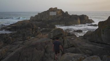 Farol da Boa Nova Portekiz, Porto 'da. Miradouro da Boa Nova. Okyanusta Capela da Boa Nova yakınlarında Oporto, Portekiz 'de gün batımında plakalı bir kaya. Hatıra mermer plaketi Antonio Nobre. 