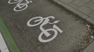 Beyaz boyayla boyanmış asfalt işareti Almanya 'da elektrikli bisikletler için park yeri anlamına geliyor. E-bisiklet park yeri tabelası. Avrupa 'da Ebike park yeri sembolü. İstasyon simgesi yükleniyor. 