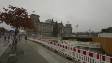 Berlin, Almanya. Deutsche Bundestag inşaat bariyerinin arkasında. Çit yenileme işi. Alman bayraklı Reichstag binası, Alman Berlin parlamentosu binası. 