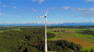 Almanya 'nın Ebersberg bölgesindeki Bavyera' daki rüzgar türbininin hava görüntüsü. Bayern, Deutschland 'deki Luftaufnahme einer Windtürbin vor dem Hintergrund der Alpen. Alplere bakan golf sahasında rüzgar türbini. 