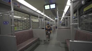 Adam Berlin, Almanya 'da metroya biniyor ve akıllı telefon kullanıyor. Banliyö treninde akıllı telefonu olan bir erkek. Berlin metrosunda internette internette sörf yapan bir yolcu. Fahrgast in der U-Bahn in Berlin, Deutschland. 