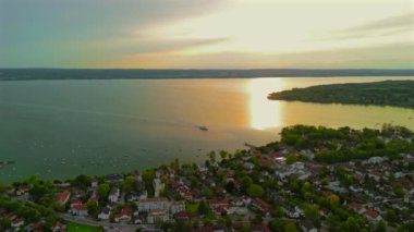 Feribot görüntüsü, Almanya 'nın Bavyera şehrinde yaz günbatımında Herrsching am Ammersee' de Ammersee Gölü 'ne yanaşıyor. Ammer Gölü 'nde seyir gemisi İHA' dan güzel gün batımı manzarası 