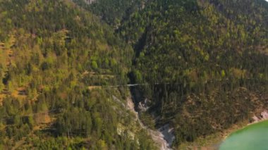 Luftaufnahme Schurpfen Wasserfall. Eğri şelale Schurpfen 'in hava manzarası ve Lenggries' deki Sylvensteinspeicher yakınlarında orman dağı ve kanyonla dolu bir köprü. İnsansız hava aracı görüntüsü düşüyor ve köprü. 