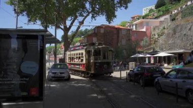 17 Ağustos 2023. Porto, Portekiz. Eski şehir Oporto 'da ünlü retro turist tramvayı ile sokak manzarası. Tramvayı olan Portekiz şehri. Tarihi tramvay hattı. Oporto 'da tipik tramvay. 