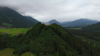 Schollanger burgkirche Fischen im Allgau, Bayern, Deutschland Luftaufnahme. Auwaldsee 'de. Dağa bakan nehir, dağlar ve Almanya 'nın Bavyera kentindeki Fischen' in tepesindeki güzel beyaz kilise.. 