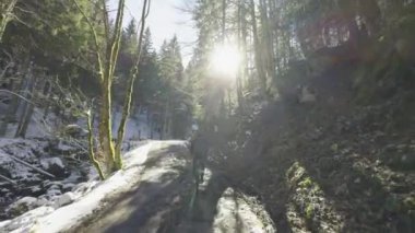 Erkek bisikletçi, Almanya 'da baharın başlarında güneşli bir havada karla kaplı yolda çakıl bisikleti sürüyor. Deutschland 'daki Tegernsee Gölü yakınlarındaki bisiklet rotaları. Karlı havada bisiklet sürmek. 