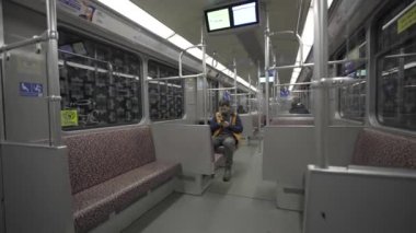 Adam Berlin, Almanya 'da metroya biniyor ve akıllı telefon kullanıyor. Banliyö treninde akıllı telefonu olan bir erkek. Berlin metrosunda internette internette sörf yapan bir yolcu. Fahrgast in der U-Bahn in Berlin, Deutschland. 