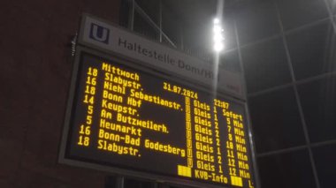 Köln ana istasyonundaki elektronik zaman çizelgesine göre Hbf gerçek zamanlı tren tarifelerini gösteriyor, gidiş ve gidiş saatlerini gösteriyor. Gezginler, yolculukları verimli bir şekilde yönetmek için bilgiye güvenirler. Haltestelle Dom. 
