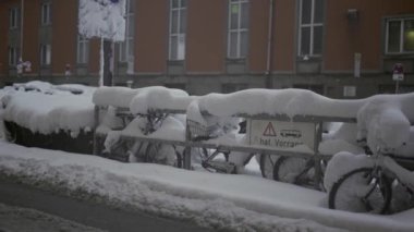Münih, Almanya. Muenchen 'de kar yağışı. Şehrin otoparkında kar bisikletleri kapladı. Otoparkta kar yağışı ve bisikletler. Schneeeinbruch Münih, Deutschland. 