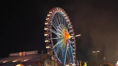 2 Ekim 2023. Almanya, Münih. Münih, Bavyera, Almanya 'da düzenlenen Ekim Festivali' nde lunaparkta gece aydınlatmalı dönme dolap. Riesenrad bei Nacht, Freizeitpark Auf Oktoberfest. 