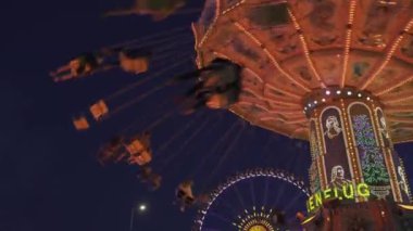  Münih, Almanya. Ekim Festivali sırasında eğlence parkındaki Viyana atlıkarıncasında güzel bir ışık vardı. Münih 'te Wiyana sosisi var. Wellenflieger Oktoberfest. 