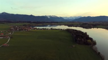 Oberbayern bei Sonnenuntergang 'dan Der Riegsee. Murnau, Bavyera, Almanya, Avrupa yakınlarındaki Riegsee Gölü 'nün havadan görüntüsü. Baharda gün batımında arka planda Ammergauer Alpen. Turizm Bölgesi Das Blaue Arazisi. 