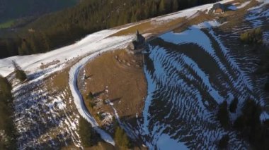 Kapelle Heilig Kreuz Rottach-Egern Tegernsee. Wallbergkapelle, Tegernsee Gölü 'ne tepeden bakan Wallberg Dağı ve güneşli bahar havasında gün batımında karla kaplı dağ sıraları. Alplerin zirvesindeki şapel. 