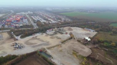 Endüstriyel bölgelerle çevrili Almanya 'daki aktif kum ocağının havadan görüntüsü. Ağır makineler sisli sonbahar atmosferinde çalışır, ham, endüstriyel manzarayı ve devam eden çıkarma çalışmalarını vurgular.. 