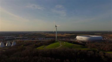 Rüzgâr türbinli Froettmaninger Mullberg 'in hava görüntüsü ve Münih' teki Allianz Arena 'nın net bir görüntüsü. Freimann rüzgar türbini ve Münih futbol arenasının kuş bakışı perspektifi. 