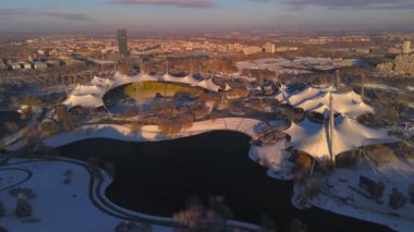 Olympiastadion im Olympiapark Munchen, Deutschland Luftaufnahme im Winter bei verschnemaddesi, sonnigem Wetter. Olimpiyat Parkı Münih 'teki Olimpiyat Stadyumu, Almanya' da kış aylarında hava durumu güneşli.. 