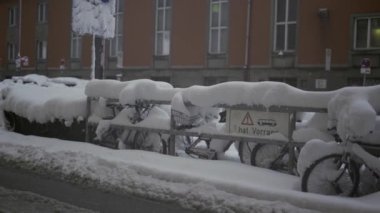 Münih, Almanya. Muenchen 'de kar yağışı. Şehrin otoparkında kar bisikletleri kapladı. Otoparkta kar yağışı ve bisikletler. Schneeeinbruch Münih, Deutschland. 