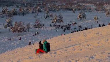 3 Aralık 2023. Münih, Almanya, Riemer Park, Messestadt. Riem parkındaki Toboggan tepesi ve gözlem güvertesi tepesi. Güneşli kış havasında Münih 'te bir parkta karlı dağda kayak yapan mutlu insanlar.. 