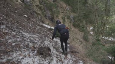 Bisikletçi dağlarda çığ üzerinden bisiklet çekiyor. Bisikletçi engelin içinde sıkıştı ve bisikletini elinde bisikletle bir buz kaydırağının içinden geçiriyor. Alplerdeki bisiklet rotasında çığ. 