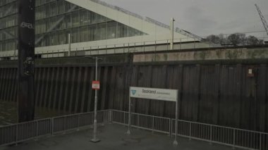 Hamburg, Almanya. Hamburg 'daki modern mimari Dockland ofis binası. Ziyaretçiler için merdiven erişimi olan rıhtım binası ve Elbe Nehri 'nin liman ve kıyısının manzarası. 