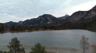 Schwansee Alp Gölü 'nden Neuschwanstein Şatosu baharda görülüyor. Schwansee im Ostallgau, Bayern sudostlich von Fussen im Gemeindegebiet von Schwangau 'da. Schloss Neuschwanstein und der See. 