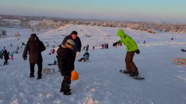 3 Aralık 2023. Münih, Almanya, Riemer Park, Messestadt. Riem parkındaki Toboggan tepesi ve gözlem güvertesi tepesi. Güneşli kış havasında Münih 'te bir parkta karlı dağda kayak yapan mutlu insanlar.. 