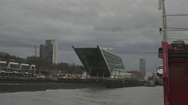 Hamburg, Almanya. Hamburg 'daki modern mimari Dockland ofis binası. Ziyaretçiler için merdiven erişimi olan rıhtım binası ve Elbe Nehri 'nin liman ve kıyısının manzarası. 