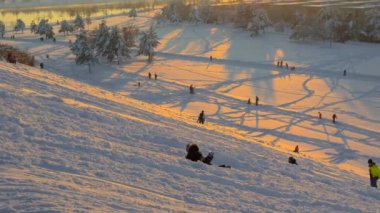 3 Aralık 2023. Münih, Almanya, Riemer Park, Messestadt. Riem parkındaki Toboggan tepesi ve gözlem güvertesi tepesi. Güneşli kış havasında Münih 'te bir parkta karlı dağda kayak yapan mutlu insanlar.. 