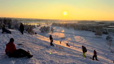 3 Aralık 2023. Münih, Almanya, Riemer Park, Messestadt. Riem parkındaki Toboggan tepesi ve gözlem güvertesi tepesi. Güneşli kış havasında Münih 'te bir parkta karlı dağda kayak yapan mutlu insanlar.. 