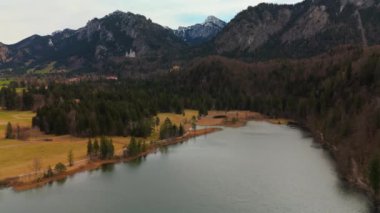 Schwansee Alp Gölü 'nden Neuschwanstein Şatosu baharda görülüyor. Schwansee im Ostallgau, Bayern sudostlich von Fussen im Gemeindegebiet von Schwangau 'da. Schloss Neuschwanstein und der See. 