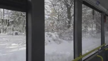 Almanya 'nın karlı Münih kentindeki otobüs penceresinden bakıldığında, karla kaplı sokaklar bir kış masalı yaratıyor. Almanya 'da yoğun kar yağışı varken toplu taşıma araçları karla kaplı şehirde ilerliyor. 