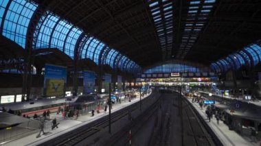 31 Aralık 2023. Hamburg, Almanya. Hamburg Hauptbahnhof, merkez istasyonunda hareketli bir akşam sahnesi. Kalabalık gezginler, aydınlanmış platformlar ve trenler şehirsel bağlantı ve hareketlilik merkezi.. 