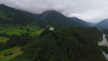 Schollanger burgkirche Fischen im Allgau, Bayern, Deutschland Luftaufnahme. Auwaldsee 'de. Dağa bakan nehir, dağlar ve Almanya 'nın Bavyera kentindeki Fischen' in tepesindeki güzel beyaz kilise.. 