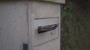 Almanya 'da bir evin önündeki posta kutusundan çıkan gazete. Konut mimarisi ile evin ön tarafı tipik bir sabah teslimatını yansıtıyor ve son haberleri kapının önüne getiriyor.. 